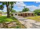 Charming single-story brick home with a long driveway, mature landscaping, and a covered front porch at 509 Falmouth St, Temple Terrace, FL 33617