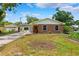 Charming single-story brick home with mature landscaping and a spacious front yard at 509 Falmouth St, Temple Terrace, FL 33617