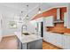 Open kitchen design with white cabinets, a center island with a sink, and stainless steel appliances at 509 Falmouth St, Temple Terrace, FL 33617