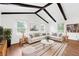 Bright living room featuring a large sectional sofa, wood floors, and vaulted ceiling with exposed beams at 509 Falmouth St, Temple Terrace, FL 33617