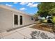 Home's backyard featuring a concrete patio, double doors, and green space at 5122 Chet Dr, New Port Richey, FL 34652