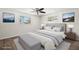 Bright bedroom featuring a ceiling fan, two windows, and a stylish bed with a bench at 5122 Chet Dr, New Port Richey, FL 34652