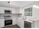 Modern kitchen with stainless steel appliances, white cabinets, and stylish track lighting at 5122 Chet Dr, New Port Richey, FL 34652