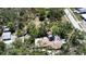 Birds-eye view of a home with white roof, surrounded by trees, showing neighborhood streets at 5680 77Th N Ave, Pinellas Park, FL 33781