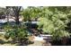 Backyard view of a home with lush, mature trees, greenery and partially shaded picnic table at 5680 77Th N Ave, Pinellas Park, FL 33781