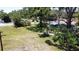 Landscaped backyard featuring mature trees, lush greenery and a quaint, partially covered patio area at 5680 77Th N Ave, Pinellas Park, FL 33781