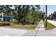 Side view of the house features mature trees and lush landscaping at 5680 77Th N Ave, Pinellas Park, FL 33781