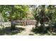 A small outbuilding sits under trees, showing a deteriorated roof and siding at 5680 77Th N Ave, Pinellas Park, FL 33781