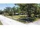 A quiet residential street showcases a charming one-story home with mature trees and lush greenery at 5680 77Th N Ave, Pinellas Park, FL 33781