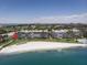 An aerial view of the condo buildings, beach and ocean with cityscape in the background at 5701 Bahia Del Mar Cir # 108, St Petersburg, FL 33715
