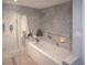 Modern bathroom featuring a luxurious soaking tub and a walk-in shower with marble-look tile at 5701 Bahia Del Mar Cir # 108, St Petersburg, FL 33715