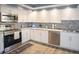 Modern kitchen featuring stainless steel appliances, white cabinets, and tile backsplash at 5701 Bahia Del Mar Cir # 108, St Petersburg, FL 33715
