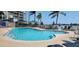 Inviting community pool surrounded by lounge chairs with ocean views beyond at 5701 Bahia Del Mar Cir # 108, St Petersburg, FL 33715