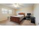 Comfortable bedroom with a wooden framed bed, desk and computer, and neutral carpet at 6100 Gulfport S Blvd # 415, Gulfport, FL 33707