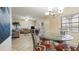 Open-concept space with a dining area, featuring a modern glass-top table and chandelier, flowing into a comfortable living area at 6100 Gulfport S Blvd # 415, Gulfport, FL 33707