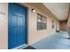 Exterior view of a unit entrance with a blue door, window and a narrow hallway at 6100 Gulfport S Blvd # 415, Gulfport, FL 33707