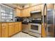 Galley kitchen with stainless steel appliances, granite countertops, wood cabinets, and natural light from the window at 6100 Gulfport S Blvd # 415, Gulfport, FL 33707