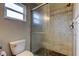 Bathroom featuring tiled walk-in shower with glass enclosure and nearby window at 6145 103Rd N Ave, Pinellas Park, FL 33782