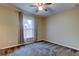This bedroom features neutral walls, soft carpeting, a ceiling fan, and a window with sheer curtains at 6145 103Rd N Ave, Pinellas Park, FL 33782