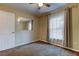 This bedroom features neutral walls, soft carpeting, a mirror, and a window with curtains at 6145 103Rd N Ave, Pinellas Park, FL 33782