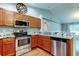 Kitchen with stainless steel appliances, warm wood cabinets, and marble countertops at 6145 103Rd N Ave, Pinellas Park, FL 33782