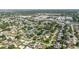 An aerial view of a suburban community showcases residences nestled amid trees and a commercial district in the distance at 6573 20Th N St, St Petersburg, FL 33702