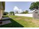 Spacious backyard with a lush lawn, storage shed, and privacy fence at 6573 20Th N St, St Petersburg, FL 33702