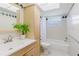 Bathroom with a bathtub-shower combination, a vanity, a tall cabinet, and a window for natural light at 6573 20Th N St, St Petersburg, FL 33702