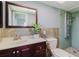 Updated bathroom featuring a modern vanity, elegant mirror and a spacious tiled shower with upgraded shower system at 6573 20Th N St, St Petersburg, FL 33702