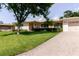 A single-story home features a well-maintained lawn, mature palm trees, and a long brick driveway to a one-car garage at 6573 20Th N St, St Petersburg, FL 33702