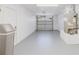 Clean garage with epoxy flooring, an automatic door opener, and a utility sink near the back at 6573 20Th N St, St Petersburg, FL 33702