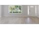 Bright living room with beautiful light-colored floors, a window and front door at 6573 20Th N St, St Petersburg, FL 33702