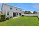 Well-maintained back yard features lush green grass, white fence, and a cozy patio area at 7732 Bulls Head Dr, Wesley Chapel, FL 33545