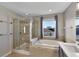 Bright bathroom featuring a glass-enclosed shower, soaking tub, and double vanity at 7732 Bulls Head Dr, Wesley Chapel, FL 33545