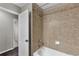 Bathtub/shower combination with neutral tiling and a functional, clean design at 7732 Bulls Head Dr, Wesley Chapel, FL 33545