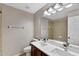Bathroom with double sink vanity, large mirror, and tiled shower/tub for a spa-like experience at 7732 Bulls Head Dr, Wesley Chapel, FL 33545