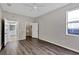 Bedroom boasts gray wood-look flooring, neutral paint, and a walk-in closet with ensuite bath at 7732 Bulls Head Dr, Wesley Chapel, FL 33545