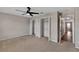 Bedroom with dual closets, ceiling fan, and plush carpet for a serene living space at 7732 Bulls Head Dr, Wesley Chapel, FL 33545