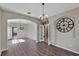 Dining room with gray walls, gray wood-look flooring, archway entrance, and decorative clock at 7732 Bulls Head Dr, Wesley Chapel, FL 33545