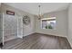 Bright dining room features a stylish chandelier, gray walls, and gray wood-look flooring at 7732 Bulls Head Dr, Wesley Chapel, FL 33545