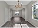 Dining room with hardwood floors, decorative chandelier, and an archway entrance at 7732 Bulls Head Dr, Wesley Chapel, FL 33545