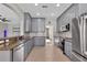 Modern kitchen with stainless steel appliances, granite countertops, and gray cabinets at 7732 Bulls Head Dr, Wesley Chapel, FL 33545