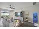 Cozy living room features a large sectional sofa, ceiling fan, and an exit to the backyard at 7732 Bulls Head Dr, Wesley Chapel, FL 33545