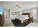 Bright and spacious main bedroom features a ceiling fan, a king bed, and an ensuite bathroom at 7732 Bulls Head Dr, Wesley Chapel, FL 33545