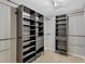 Walk-in closet featuring custom shelving, drawers and clothing bars for efficient storage at 7732 Bulls Head Dr, Wesley Chapel, FL 33545