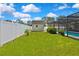 A spacious backyard featuring a shed, white fencing, and a screened-in pool at 7818 Holiday Dr, Spring Hill, FL 34606