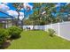 Beautiful backyard with green grass, white fence, and a fire pit at 7818 Holiday Dr, Spring Hill, FL 34606
