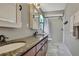 Bathroom featuring dual sinks, granite countertop, and a shower-over-tub at 7818 Holiday Dr, Spring Hill, FL 34606
