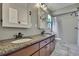Bathroom featuring dual sinks, granite countertop, and a shower-over-tub at 7818 Holiday Dr, Spring Hill, FL 34606