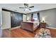 Cozy bedroom features wood floors, fan, gray walls, and unique sliding barn doors at 7818 Holiday Dr, Spring Hill, FL 34606